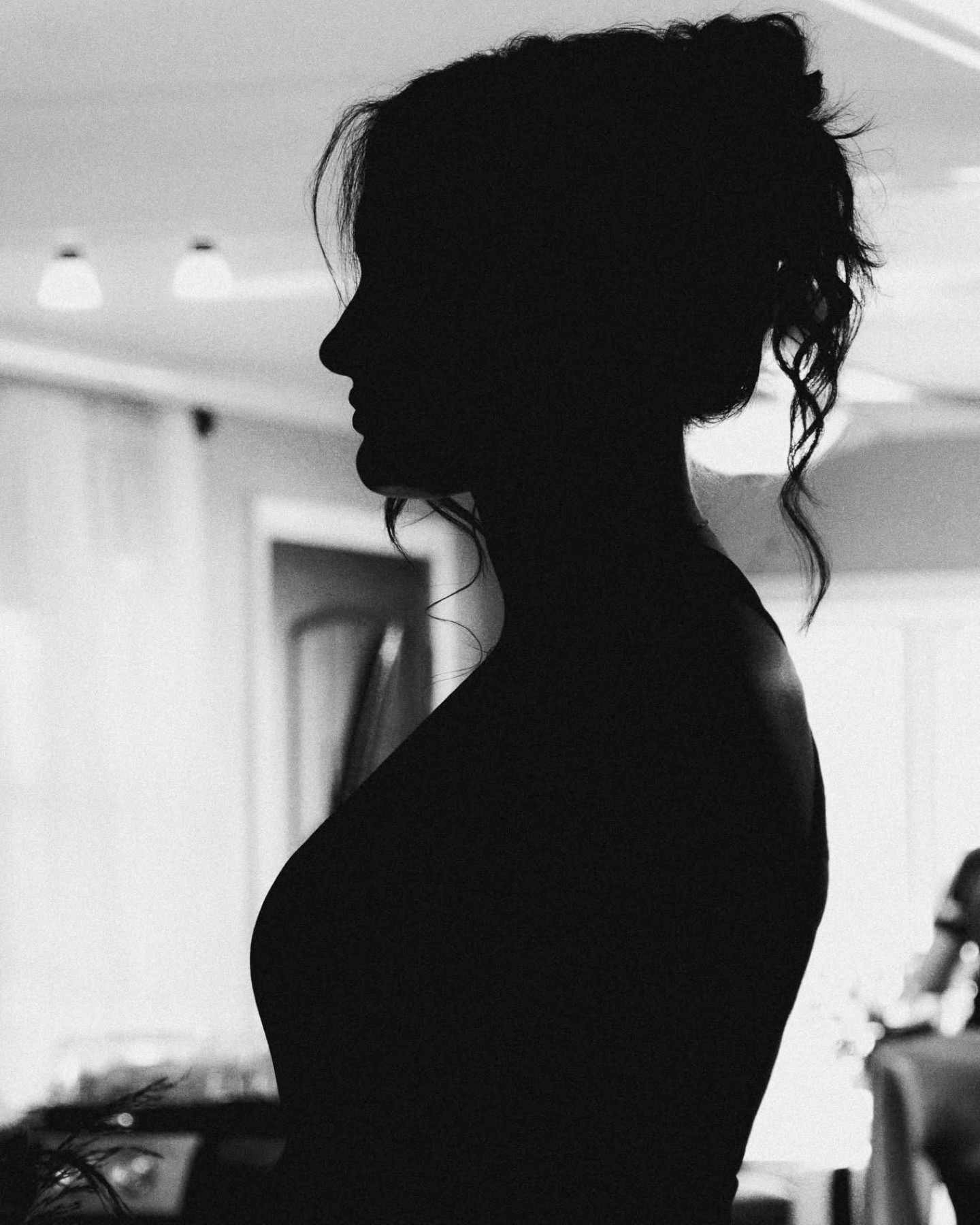 Black-and-white silhouette of a bride getting ready