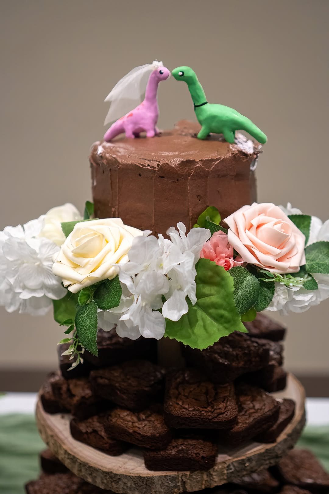 Chocolate wedding cake with playful dinosaur toppers