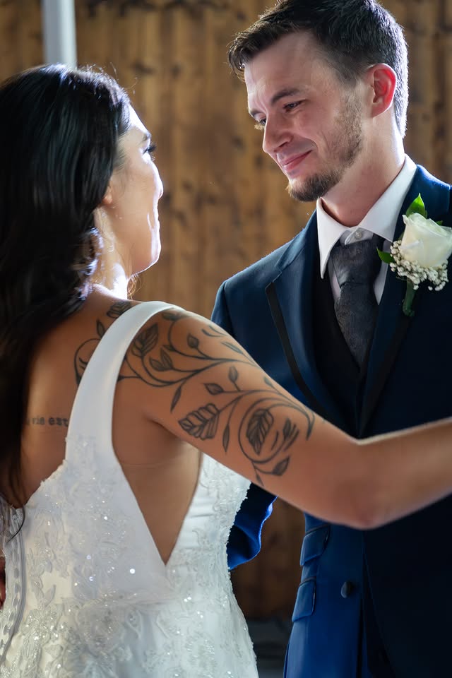 A groom smiles at his bride