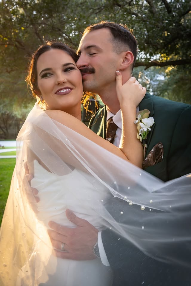 Newlyweds embrace in warm evening light